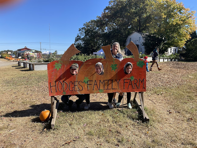 Andy, Elizabeth, and you with your heads in the pumpkin sign with me standing behind you at the pumpkin patch.