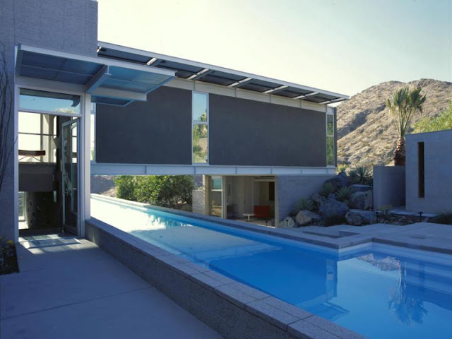 Photo of house and the pool passing below it