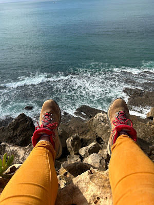 Sitting with feet off the side of the cliff over the Atlantic