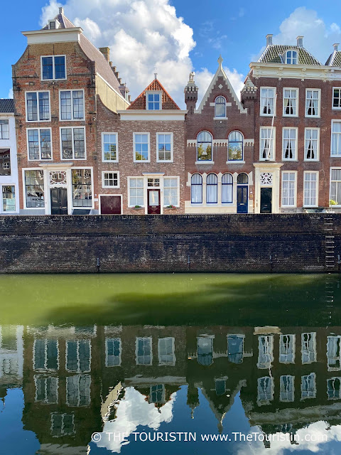 A row of colourful Dutch gabled period houses on a canal..