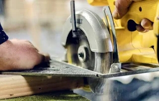 Man cutting wood with a rotary saw.