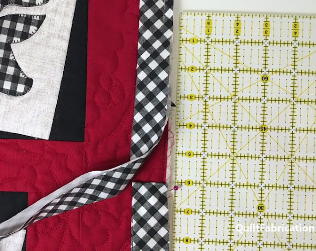 black and white check binding stitched to a quilt