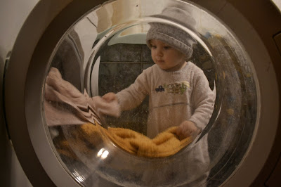ребенок в ванной комнате, видно через дверцу стиральной машинки