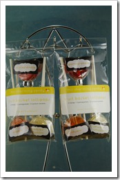two plastic bags of fruit-flavored lollipops hanging from a chome stand