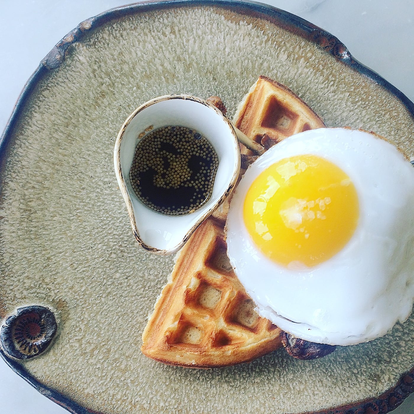 Duck and Waffle's signature dish, a plate of confit duck on top of a waffle with a friend egg, one of the best luxury london breakfast spots