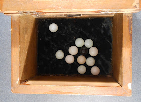 Image of fraternity "blackball" box with one black ball