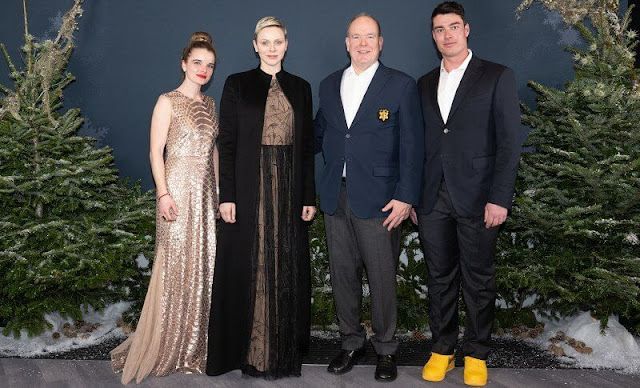 Princess Charlene wore a belted embroidered tulle gown by Akris, and black long wool coat by Akris at Ineos Club House