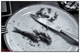 Sardines on the plate, knife and fork, at Trattoria Da Oscar.  Photograph by Kent Johnson