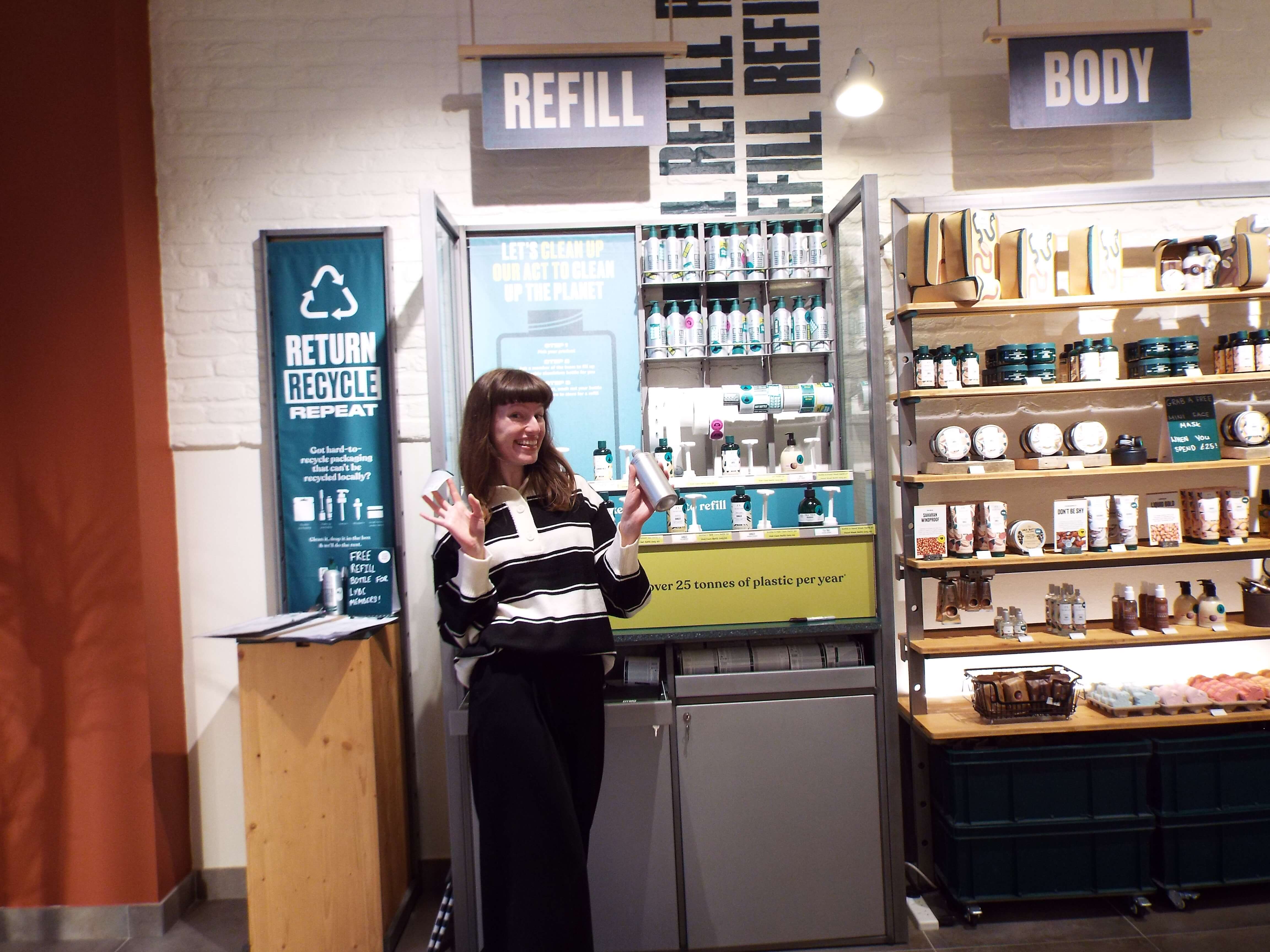 Me smiling, with jazz hands and a refill bottle held up, with a right cheesy grin, at the refill station.