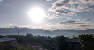 The sun rises over a misty valley