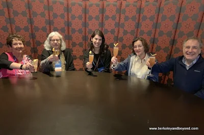 happy group lifts their cocktails in a toast at The Citizens Trust in Columbus, Ohio