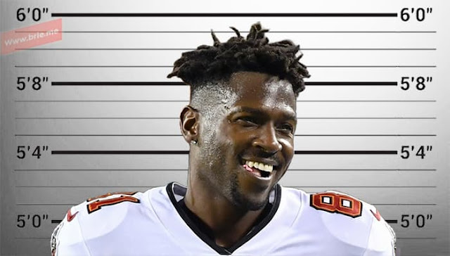 Antonio Brown posing in front of a height chart background
