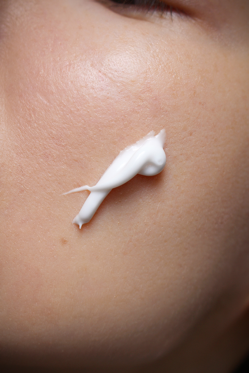 close-up shot of females face with a smudged moisturizer on a cheek