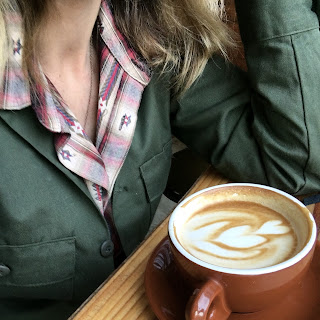 a woman sitting with a cup of coffee