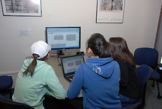 Students using Milne's collaborative computer monitors in the main floor study area.