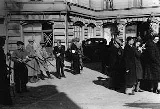 Members of Latvian Auxiliary Police assemble a group of Jews, Liepāja, July, 1941.