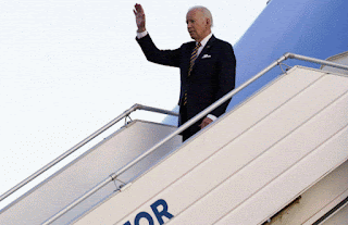 Joe Biden levant la main pour saluer le public