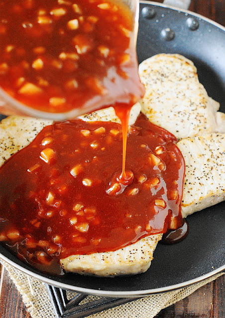 Pouring BBQ Sauce Over Seared Pork Chops in Pan Image