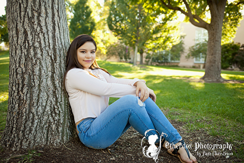 Professional photograph of an Atrisco high school senior on top at the UNM Duck Pond Albuquerque