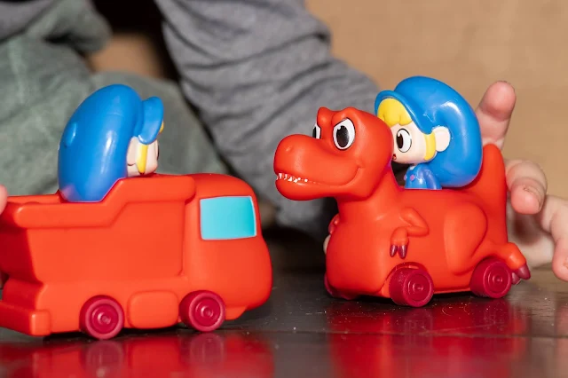 A close up of 2 of the Morphle toy vehicle toys one is a truck and the other a dinosaur