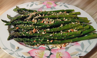 asparagus topped with dressing and almonds