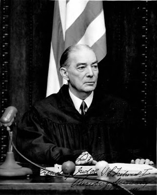 photo of judge on bench in front of US flag