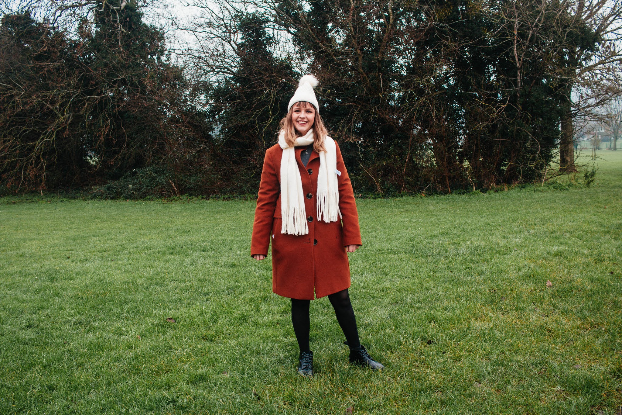 Girl dressed in coat, hat & scarf, in nature. January 2021 habits and goals blog post