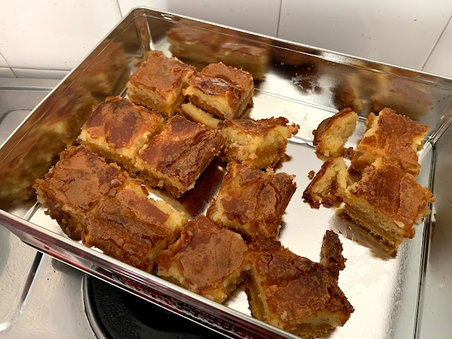 Squares of gooey butter cake in a metal tin