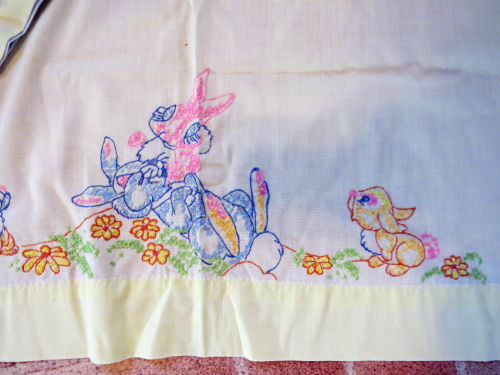 crib sheet edge with embroidered rabbits