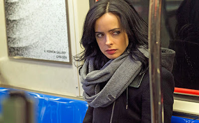 Jessica Jones sentada no metrô, interpretada pela atriz Krysten Ritter.