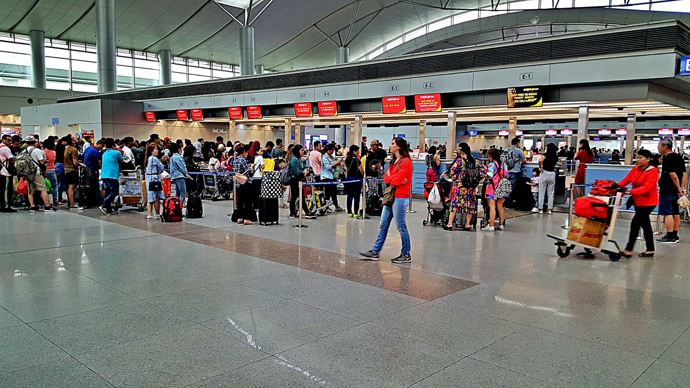 early morning crowded vietjet check-in counters at Tan Son Nhat International Airport