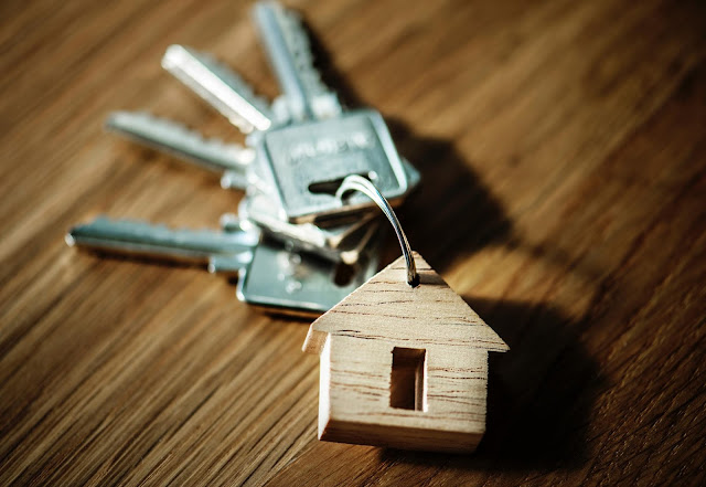 Keys laid out on a table with a house shaped key ring