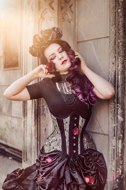 Women's steampunk gothic clothing with a floral crown, black skirt, corset, and top.