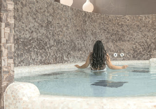 a girl wades in a crystal-clear hydropool.