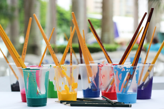 paintbrushes in plastic cups via unsplash.com