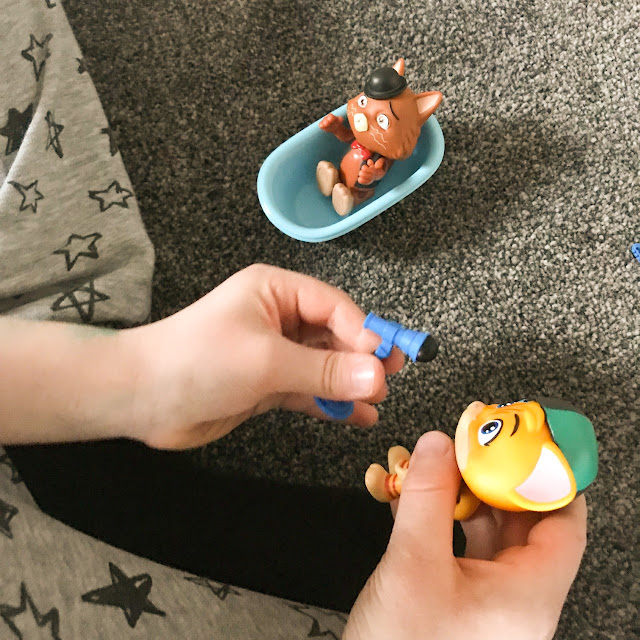 Close up of a child's hands holding and playing with the figures