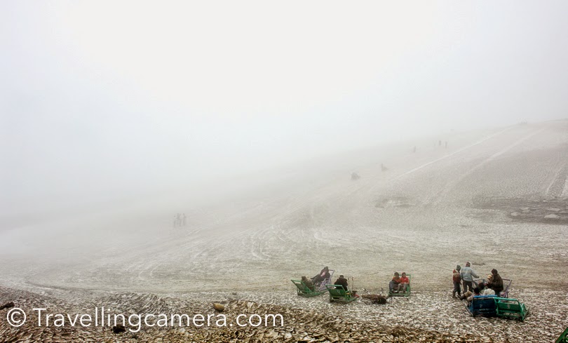 It was very foggy and we could hardly see beyond the road. As we got down from our car, there were lot of kiosks to rent out snow gears. Before taking any decision, we planned to get climb to the area where lot of tourists were having fun on snow scooters. The snow was very dirty as you can see in these photographs. Because this was not fresh snow and this road becomes very busy during summers, all the dust settles down on white snow and the whole space looks very dirty.  In fact, this is the time when snow is hard. It was very disappointing for us, but we were happy that we would be seeing snow on next terrains where tourist cars hardly go to make these white landscapes dirty.