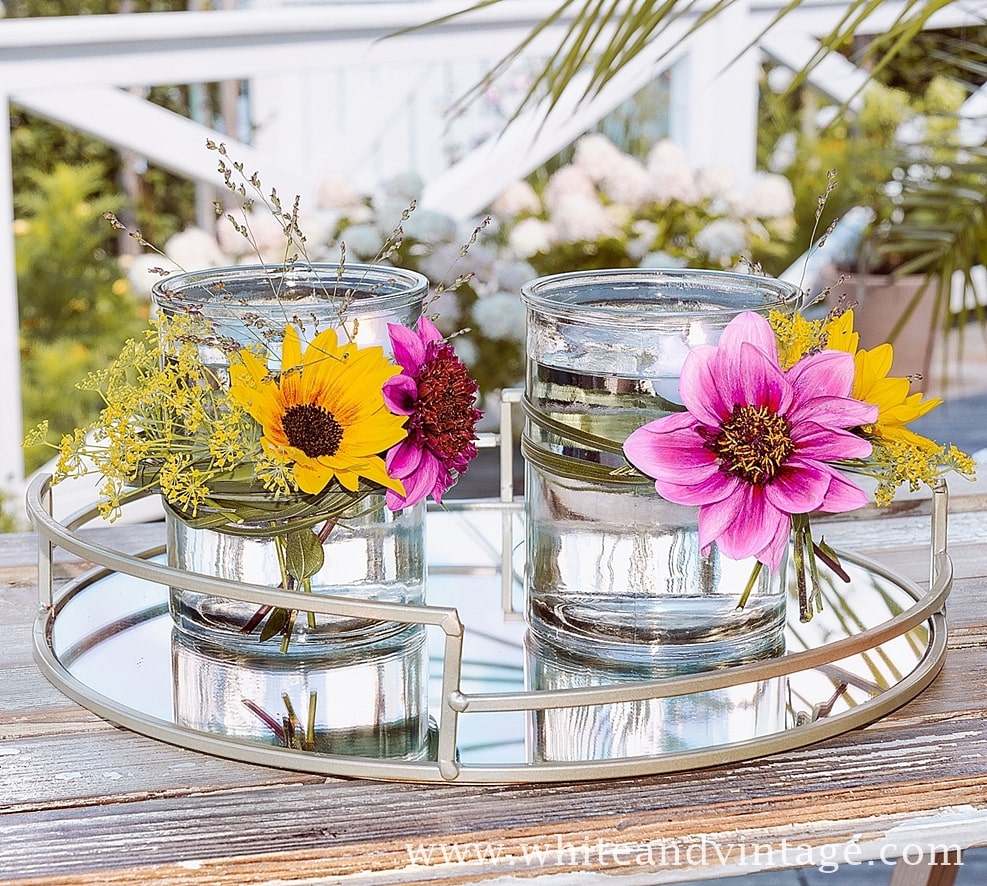 Glas mit Blumen und Schwimmkerze dekorieren.