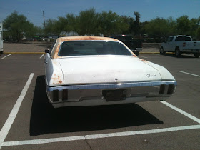 Rear view of 1970 Chevrolet Bel Air with rusty roof and rear fender parked in parking lot