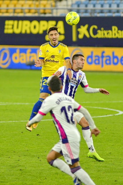 Alfonso Espino despeja ante Sergi Guardiola mientras Orellana sigue la jugada. CADIZ C. F. 0 REAL VALLADOLID C. F. 0. 29/12/2020. Campeonato de Liga de 1ª División, jornada 15. Cádiz, estadio Ramón de Carranza.