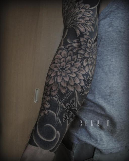 an interesting tattoo design, covering the whole arm with floral patterns