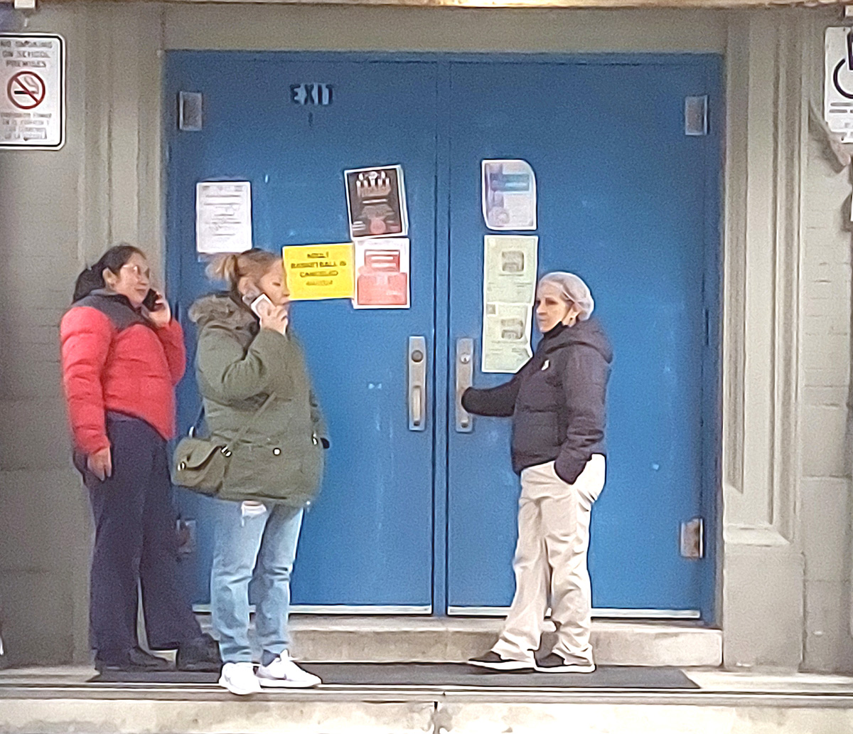 At least one parent and a school employee wait outside of P.S. 86 on Reservoir Avenue that was apparently put on lockdown after a reported earthquake felt across New York City on Friday, April 5, 2024. -Photo by David Greene