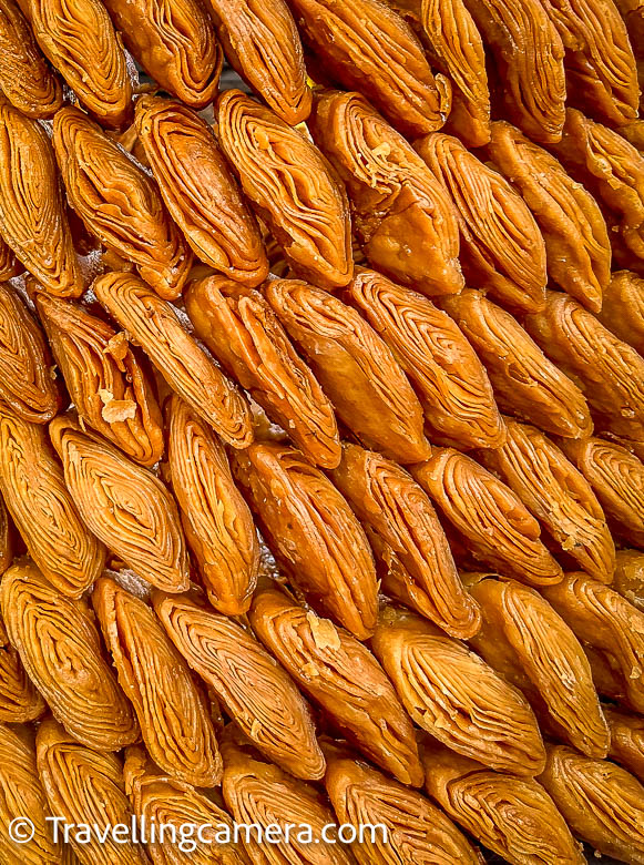 The Making of Khaja:  Ingredients of Khaja: Khaja primarily consists of all-purpose flour (maida), sugar or jaggery, ghee (clarified butter), and cardamom for flavoring. These simple ingredients are transformed into a sweet masterpiece through a series of steps.  Layering Technique of Khaja : The key to Khaja's unique texture lies in its layering technique. The dough is rolled out into thin sheets, which are then layered with ghee and folded multiple times. This process is repeated several times to create multiple layers.  Frying process of Khaja : Once the layered dough is ready, it is cut into desired shapes, typically diamond-shaped. These pieces are deep-fried until they turn golden brown, resulting in a crispy outer layer.  Sugar Syrup for Khaja: After frying, the Khaja pieces are dipped in sugar syrup, which gives them a sweet and slightly sticky coating. The sugar syrup is often flavored with cardamom, adding a delightful aroma.