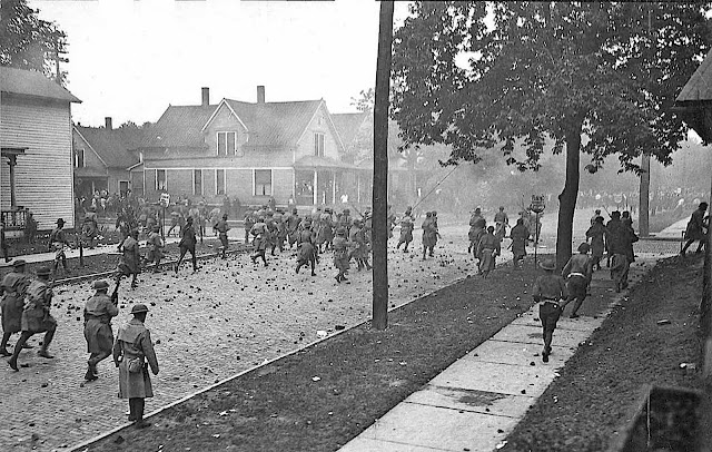 breaking the striking textile workers in 1934 USA, a photograph of charging soldiers in a residential neighborhood