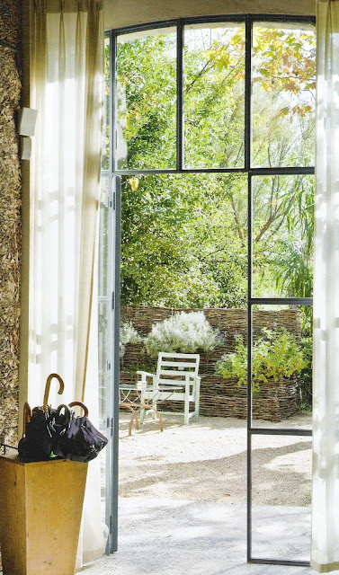 Iron and glass doors, view to patio garden via Côte Maison Francaise, edited by lb for linen & lavender