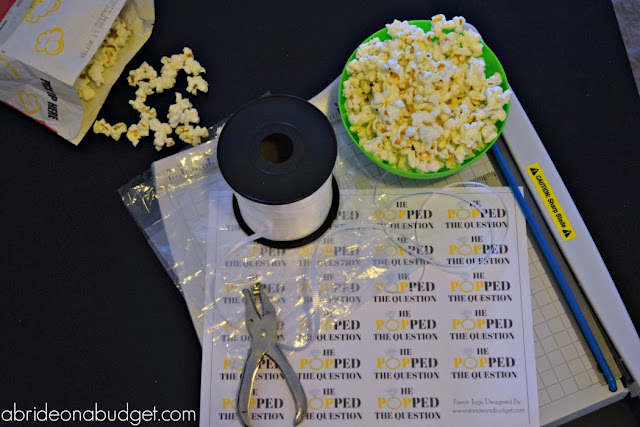 Here's a FUN and cheap engagement party favor. Use popcorn and make these He Popped The Question Engagement Party Favors from www.abrideonnabudget.com. Even better, you can get the printable tag for FREE in the blog post!