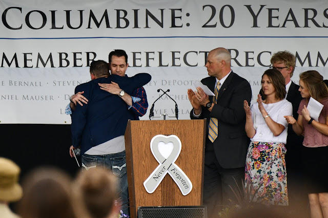 Sean Graves y Patrick Ireland se abrazan durante la ceremonía por el 20º aniversario de Columbine