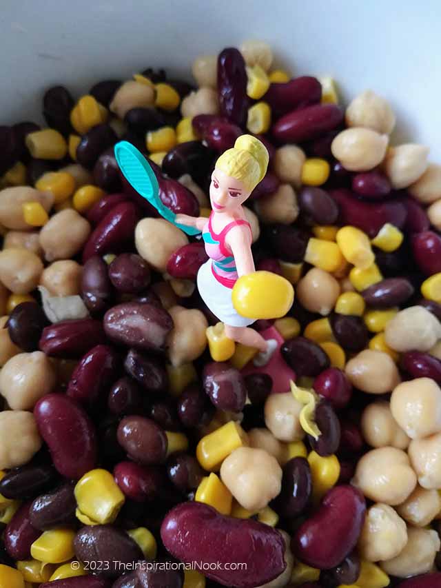 Mexican 3 bean salad, lime juice dressing, Mexican Corn and Bean salad, Mexican three bean salad, Black bean and corn salsa, end of summer salad, figure holding a tennis ball of corn in a bowl of beans and corn