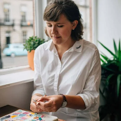 seated artist cutting paper