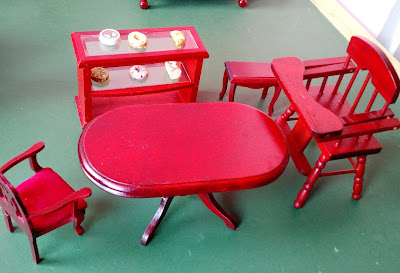 Miniatura de móveis de madeira da sala de jantar: mesa oval  R$ 25,00; cadeira com braços  R$ 12,00; (vendidos  bufe com vidro com com pães e bolos R$ 22,00;  mesinha R$ 10,00 e cadeira alta de alimentação  R$ 15,00)